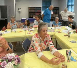 People doing crafts and talking at a Memory Cafe dementia support program